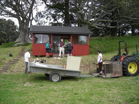 The tractor with trailer and cage attached being used to install the kiosk on Motuihe